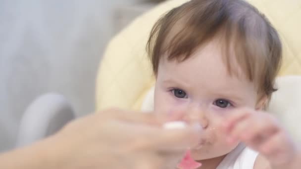 Infant eats baby food with pleasure. - Filmati, video