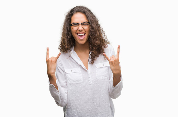 Красива молода іспаномовна жінка, що кричить з божевільним виразом робить рок-символ руками вгору. Музична зірка. Важка концепція
. - Фото, зображення