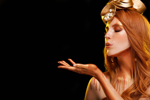 Menina modelo Beauty Fashion com maquiagem dourada, maquiagem de pele dourada, cabelo e jóias em fundo preto
. - Foto, Imagem