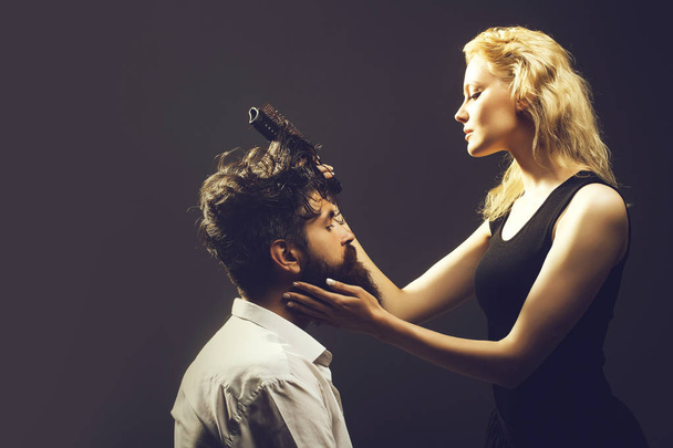 blonde hairdresser combing bearded man - Foto, afbeelding