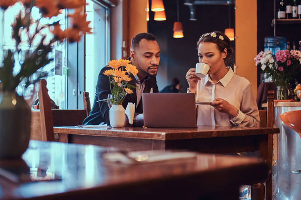 Üzleti tárgyalásokon megvitatni működő pillanatok-val laptop ebédidőben étteremben vonzó afro-amerikai házaspár. - Fotó, kép
