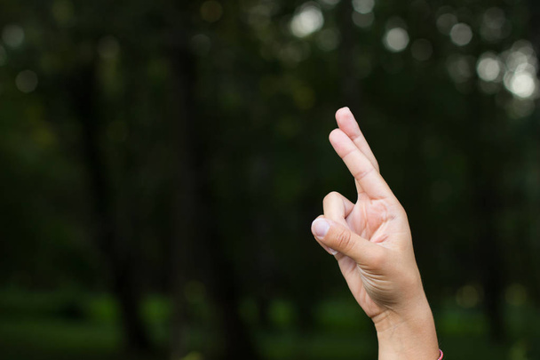 Zeichen und Symbole für Menschen mit Behinderungen stumme und taube Menschen Konzept des Daktylalphabets durch weibliche Hand und Finger mit Leerraum für Kopie oder Text auf unfokussiertem dunklen Hintergrund - Foto, Bild