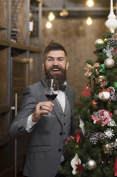Thanksgiving Day greeting toast of guy. Thanksgiving day with happy bearded man holding wine glass at new year tree - Φωτογραφία, εικόνα