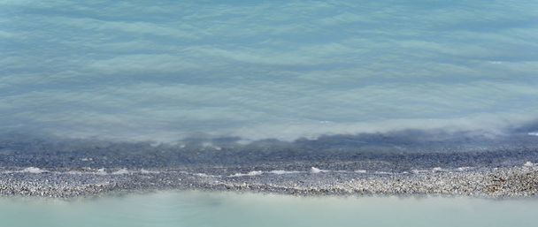 achtergrond - de rand van de oever van de vijver van soda plant met turkoois water staart - Foto, afbeelding