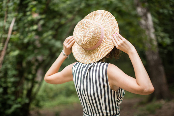 girl in a hat and dress walking in the woods - Fotografie, Obrázek