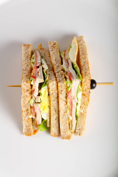 Sandwich club avec viande, fromage et légumes
 - Photo, image