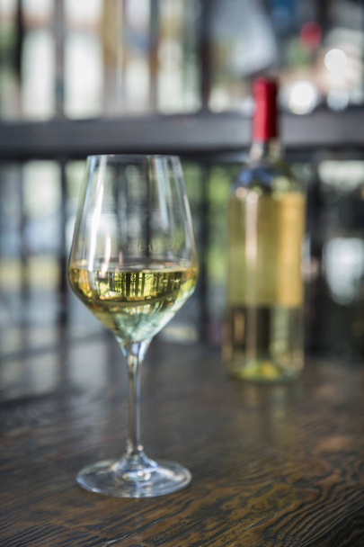 Бутылка и бокал белого вина на белом фоне
 - Фото, изображение