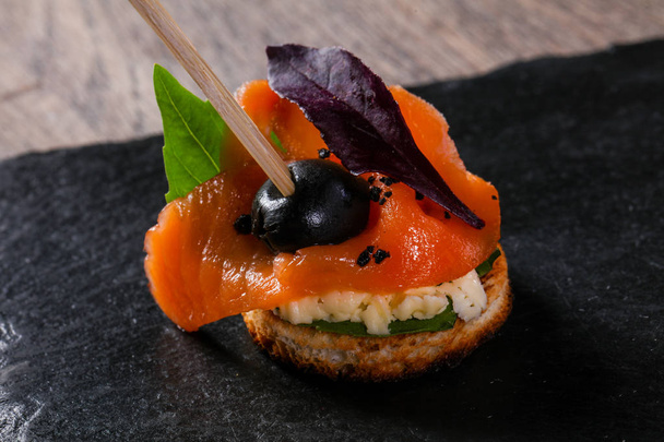 Canape with salmon and salad leaves - Фото, изображение
