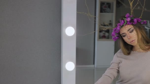 Жінка в квітковому вінку стоїть з дзеркалами позаду
 - Кадри, відео