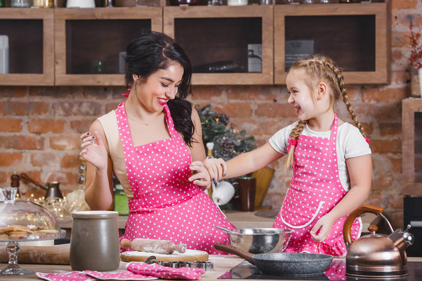 若い美しい母親と彼女の小さな娘が一緒にキッチンで料理 - 写真・画像