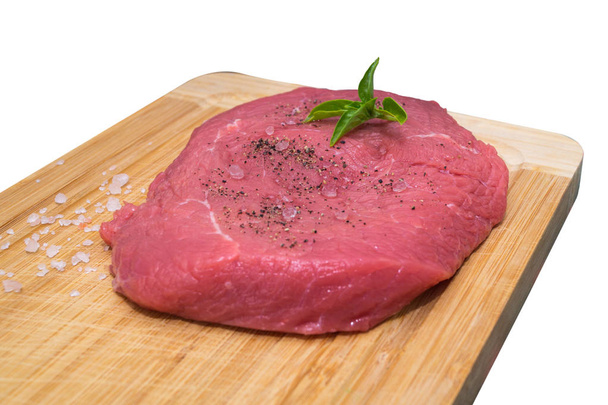 steak de boeuf cru sur planche à découper avec tomates cerises et feuilles de basilic
 - Photo, image