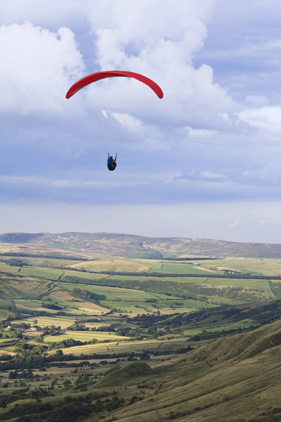 Peak District, UK - August 08, 2007. Paragliding over Edale Valley in the Peak District, Derbyshire. The pilot gains lift from the strong updraft that occurs on windward hill slopes. - Foto, Imagen