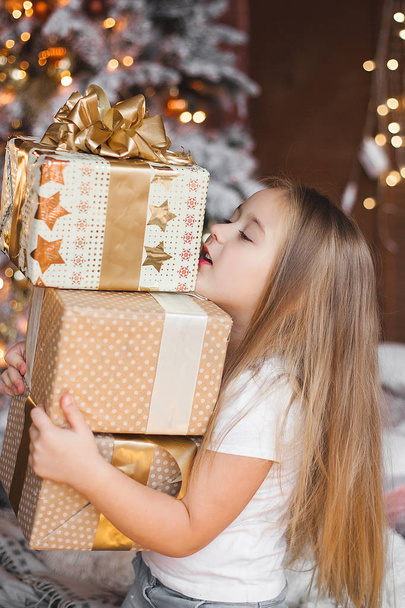 Мила маленька дитина тримає різдвяні подарунки
 - Фото, зображення