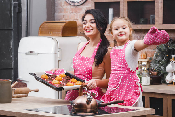 Iloinen perhe keittiössä leivontaan muffinsseja tai cupcakes
 - Valokuva, kuva