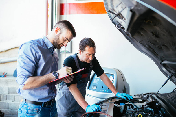 Otomobil tamircileri araba tamir ediyor.  - Fotoğraf, Görsel