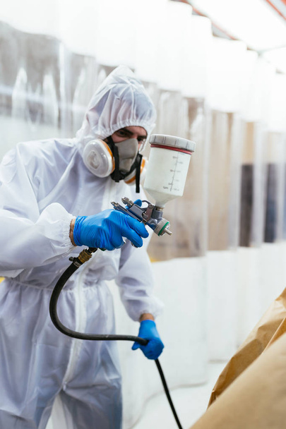 Hombre con ropa protectora y máscara pintura coche usando compresor de pulverización
 - Foto, imagen