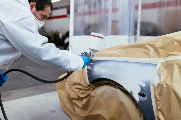 Ember, védőruha és maszk festés autó kompresszor spray használata. Szelektív összpontosít. - Fotó, kép