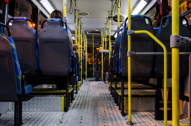 Інтер'єр порожнього колективного автобуса вночі, видно з нижніх крісел
 - Фото, зображення