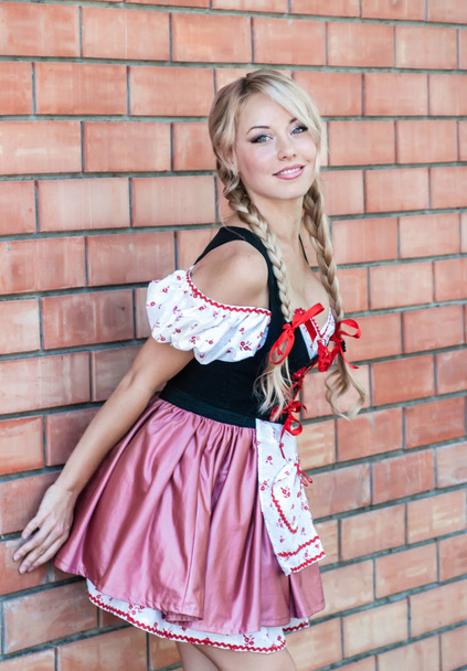 Gyönyörű fiatal nő, a kő háttér Octoberfest ruha. - Fotó, kép