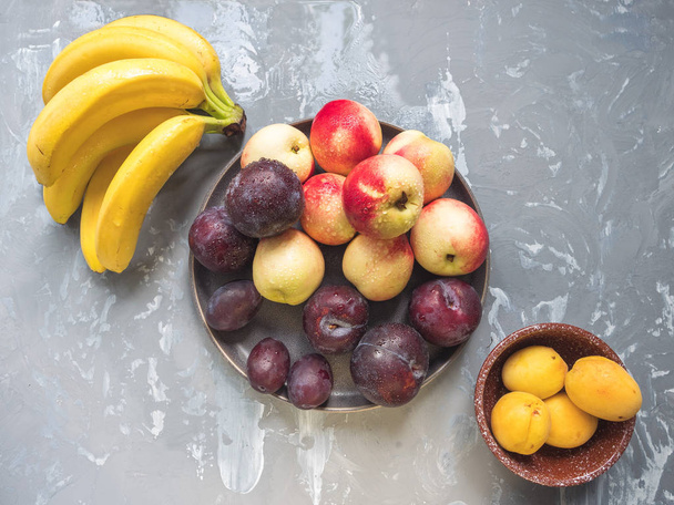 conjunto de frutas plátanos nectarinas ciruelas rojas vista desde arriba
 - Foto, imagen