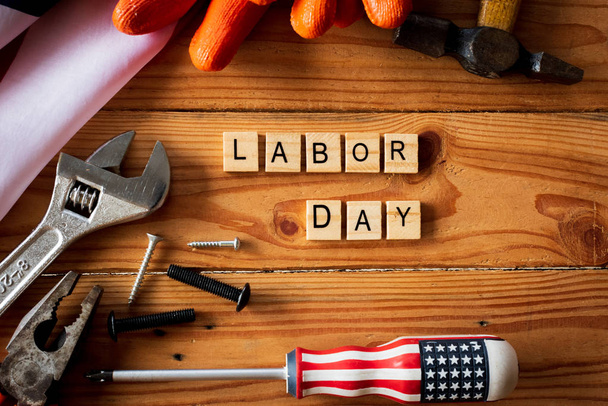 USA Labor day concept, Primo lunedì di settembre. Diversi tipi su chiavi, pratici utensili, bandiera americana e blocchi di legno su tavolo di legno
. - Foto, immagini