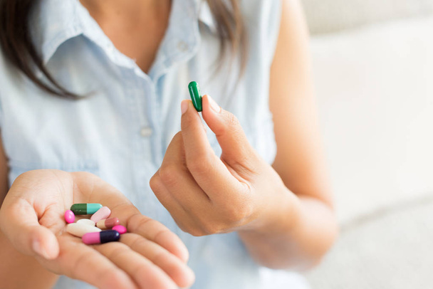 Nő kézzel tabletták gyógyszert tabletta és kapszula a kezében. Egészségügy, egészségügyi kiegészítők koncepció - Fotó, kép