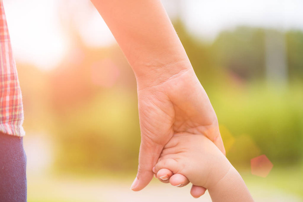 Close up mother holding a child's hand. Family and Mothers day concept. - Fotoğraf, Görsel