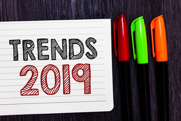 Word writing text Trends 2019. Business concept for Upcoming year prevailing tendency Widely Discussed Online Notebook paper colorful markers wooden background communicating ideas - Photo, Image
