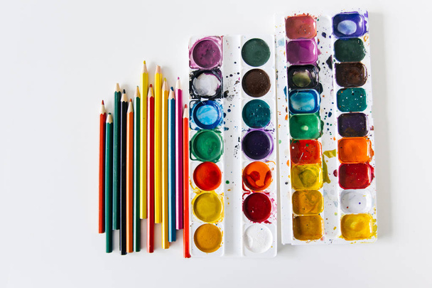 Set of watercolor paints and paintbrushes on a table - Фото, зображення