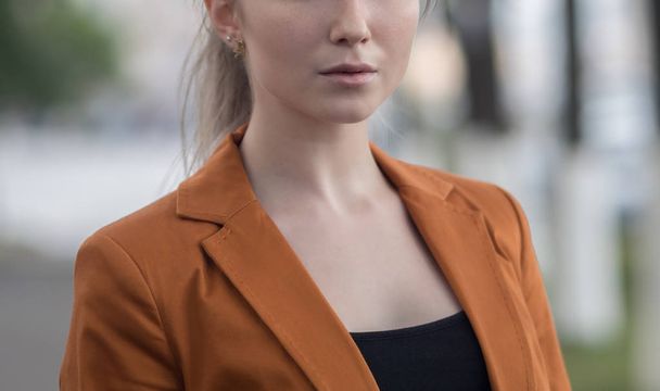 Portrait of a young woman in an orange jacket. - Zdjęcie, obraz