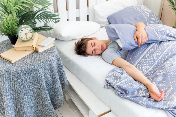 Handsome young man sleeping in white bedding - Photo, image