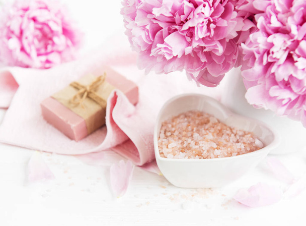 barres de savon fait main, serviettes douces et fleurs pivoines sur une table en bois blanc
 - Photo, image
