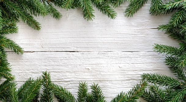 Christmas background with fir branches on white wooden board - Photo, Image
