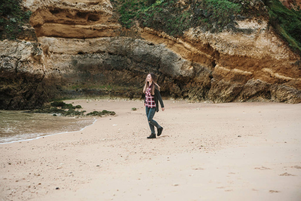 Μια όμορφη κοπέλα που τρέχει γύρω από την ακτή του Ατλαντικού στην Πορτογαλία και απολαμβάνει τη ζωή. - Φωτογραφία, εικόνα