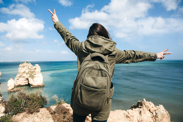 Ένας τουρίστας νεαρή γυναίκα απολαμβάνει όμορφη θέα στον Ατλαντικό Ωκεανό και το τοπίο. - Φωτογραφία, εικόνα