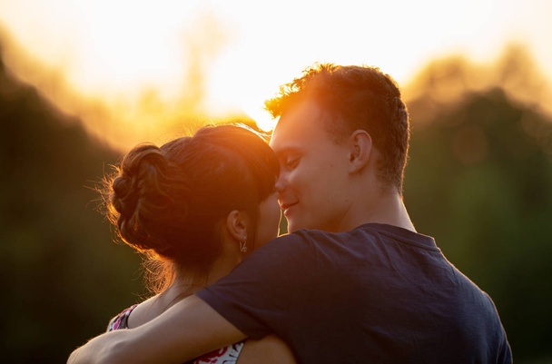Lovely young couple at sunset, closeup shot - Foto, afbeelding