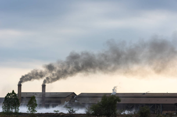 Air pollution with black smoke from chimneys and industrial waste. - Photo, Image
