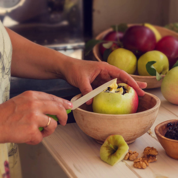 Bratapfel. Frau füllt die Äpfel mit Mohn, Quark, Rosinen, Zucker und Butter. quadratisches Foto - Foto, Bild