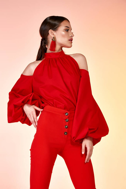 Pretty beautiful sexy elegance woman fashion model glamor pose wear red color trousers silk blouse clothes for party summer collection makeup hair style brunette success accessory bag jewelry studio. - Foto, imagen
