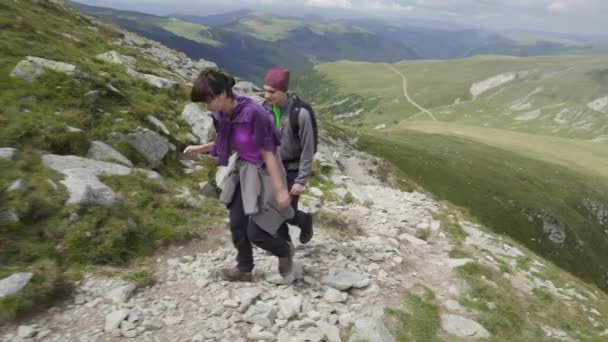 A fiatal pár a túrázás, a hegyi ösvényen  - Felvétel, videó