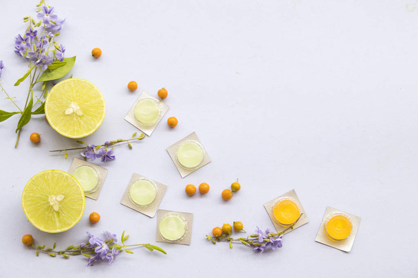 kaszel, ból gardła Pastyła pigułki z ziołowych cytryny z aranżacją fioletowe kwiaty na białym tle - Zdjęcie, obraz