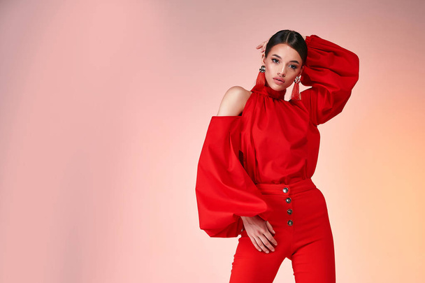 Pretty beautiful sexy elegance woman fashion model glamor pose wear red color trousers silk blouse clothes for party summer collection makeup hair style brunette success accessory bag jewelry studio. - Фото, зображення