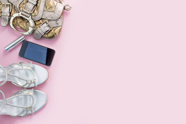Nowoczesny sposób akcesoria młodych kobiet buty torebka telefon gadżet szminka kosmetyki różowy tło. - Zdjęcie, obraz