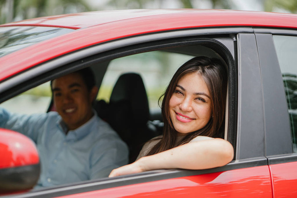 Portrét mladé japonské asijské ženy vyklání z okna okno červené auto a šťastně se usmívala.  - Fotografie, Obrázek