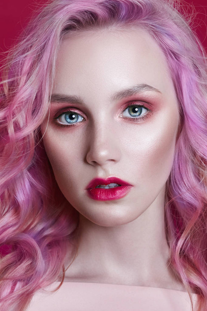 Portrait of a woman with bright colored flying hair, all shades of pink purple. Hair coloring, beautiful lips and makeup. Hair fluttering in the wind. Sexy girl with long hair - Photo, Image