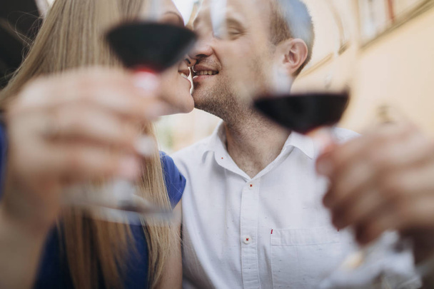 Cheerful couple in a restaurant with glasses of red wine.  Young - Φωτογραφία, εικόνα