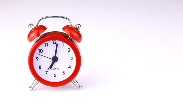 白い背景に分離されたビンテージ赤い目覚まし時計のクローズ アップ ビュー - 映像、動画