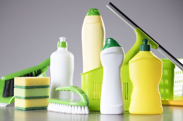 Ház és iroda takarítás megjelöl téma. Meg a színes tisztítási termékek szürke háttér. Hely a logó, szöveg vagy tipográfia. - Fotó, kép