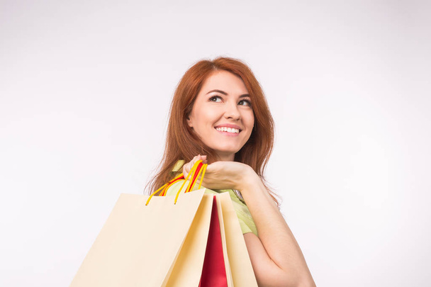 Verbraucher-, Verkaufs- und People-Konzept - rothaarige Frau mit Einkaufstüten im Stil - Foto, Bild