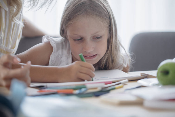 Linda loira caucasiana menina pré-escolar escrevendo cartas em seu caderno
. - Foto, Imagem